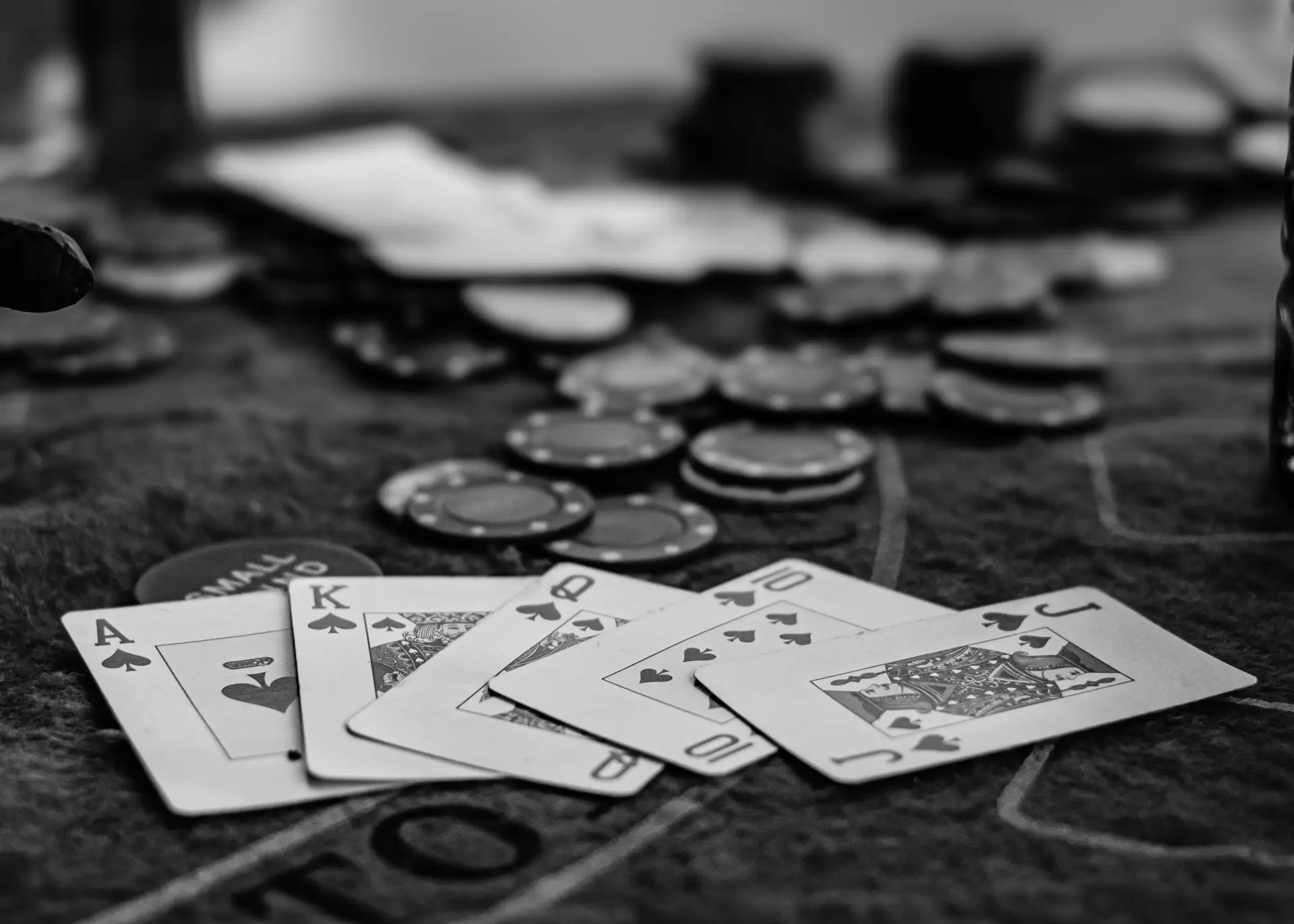 Atmosphärischer Pokertisch mit Karten und Chips im Halbdunkel