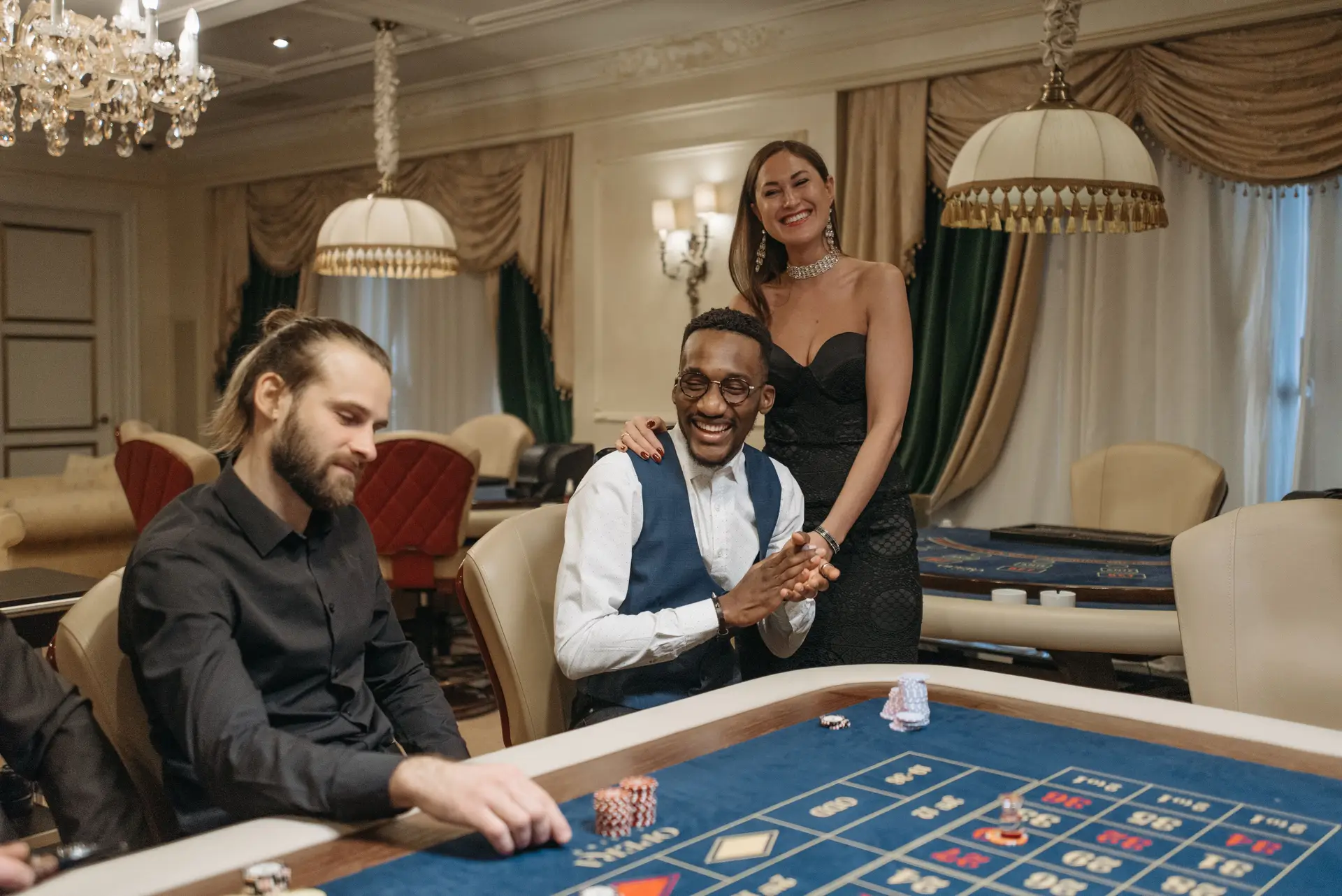 Filmszene mit drei Akteuren am eleganten Spieltisch